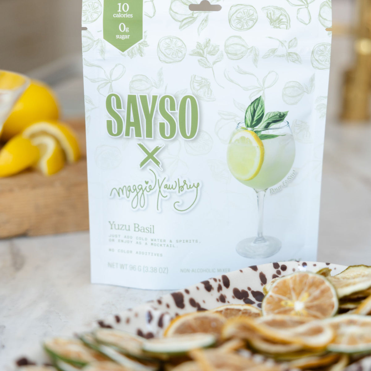 SAYSO x Maggie Awbrey Yuzu Basil drink mixes on a counter next to garnish